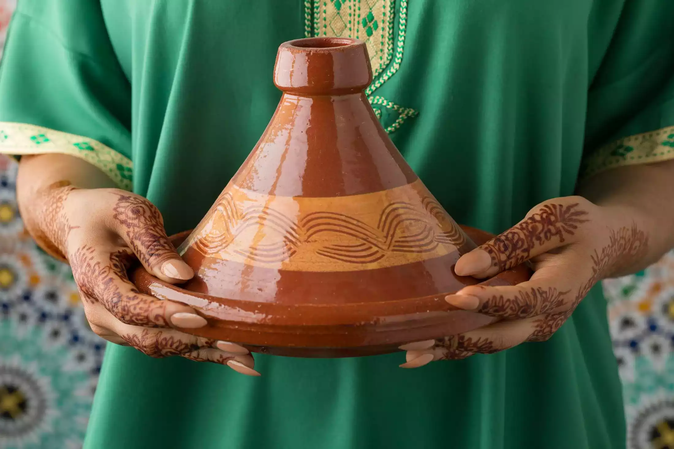 Moroccan woman with henna painted hands holding a tagine
