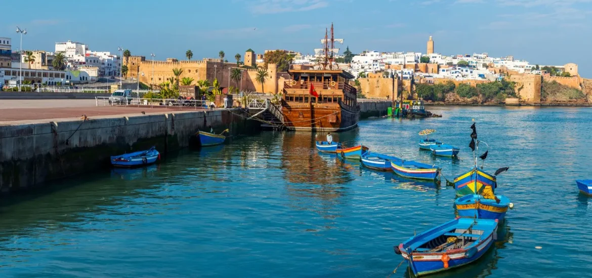 Traditional fishing boats on the Bouregreg River at Corniche de Rabat, with the city’s medina and historic walls in the background.